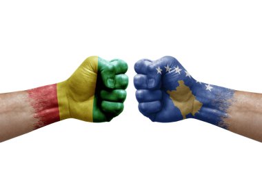 Two hands punch to each others on white background. Country flags painted fists, conflict crisis concept between guinea and kosovo