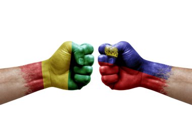 Two hands punch to each others on white background. Country flags painted fists, conflict crisis concept between guinea and liechtenstein