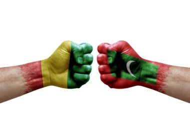 Two hands punch to each others on white background. Country flags painted fists, conflict crisis concept between guinea and maldives