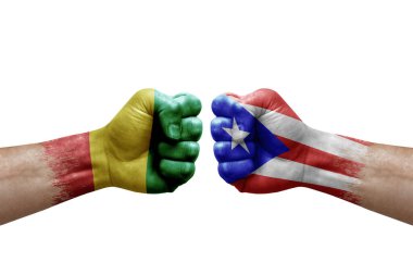 Two hands punch to each others on white background. Country flags painted fists, conflict crisis concept between guinea and puerto rico