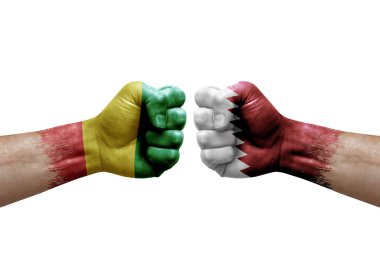 Two hands punch to each others on white background. Country flags painted fists, conflict crisis concept between guinea and qatar