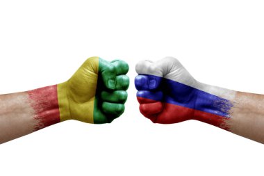 Two hands punch to each others on white background. Country flags painted fists, conflict crisis concept between guinea and russia