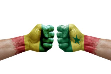 Two hands punch to each others on white background. Country flags painted fists, conflict crisis concept between guinea and senegal