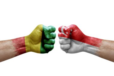 Two hands punch to each others on white background. Country flags painted fists, conflict crisis concept between guinea and singapore