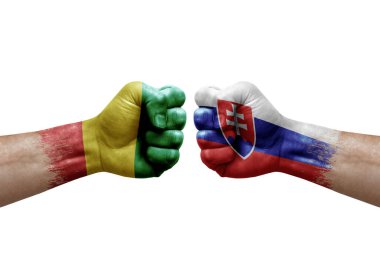 Two hands punch to each others on white background. Country flags painted fists, conflict crisis concept between guinea and slovakia