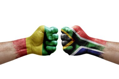 Two hands punch to each others on white background. Country flags painted fists, conflict crisis concept between guinea and south africa