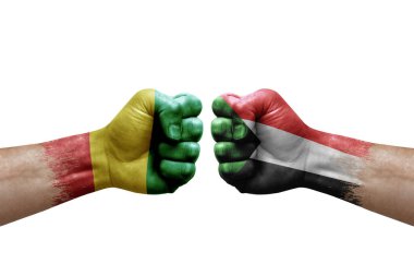 Two hands punch to each others on white background. Country flags painted fists, conflict crisis concept between guinea and sudan