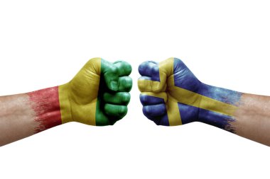 Two hands punch to each others on white background. Country flags painted fists, conflict crisis concept between guinea and sweden