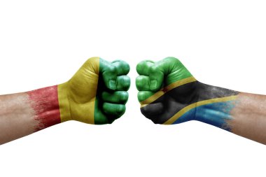 Two hands punch to each others on white background. Country flags painted fists, conflict crisis concept between guinea and tanzania