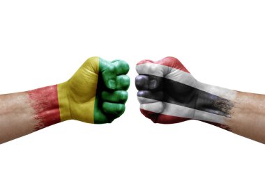 Two hands punch to each others on white background. Country flags painted fists, conflict crisis concept between guinea and thailand