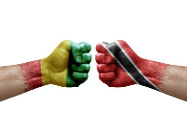 Two hands punch to each others on white background. Country flags painted fists, conflict crisis concept between guinea and tobago