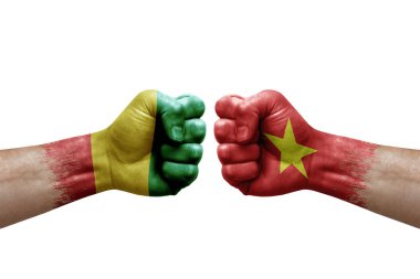 Two hands punch to each others on white background. Country flags painted fists, conflict crisis concept between guinea and vietnam