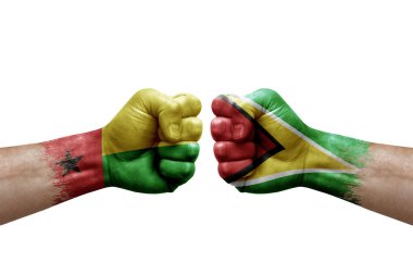 Two hands punch to each others on white background. Country flags painted fists, conflict crisis concept between guinea-bissau and guyana