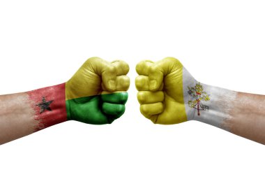 Two hands punch to each others on white background. Country flags painted fists, conflict crisis concept between guinea-bissau and holy see