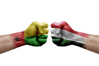 Two hands punch to each others on white background. Country flags painted fists, conflict crisis concept between guinea-bissau and hungary