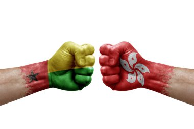 Two hands punch to each others on white background. Country flags painted fists, conflict crisis concept between guinea-bissau and hong kong
