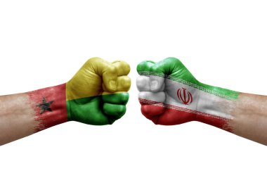 Two hands punch to each others on white background. Country flags painted fists, conflict crisis concept between guinea-bissau and iran