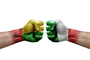 Two hands punch to each others on white background. Country flags painted fists, conflict crisis concept between guinea-bissau and italy