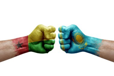 Two hands punch to each others on white background. Country flags painted fists, conflict crisis concept between guinea-bissau and kazakhstan