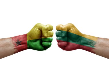 Two hands punch to each others on white background. Country flags painted fists, conflict crisis concept between guinea-bissau and lithuania