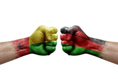 Two hands punch to each others on white background. Country flags painted fists, conflict crisis concept between guinea-bissau and malawi