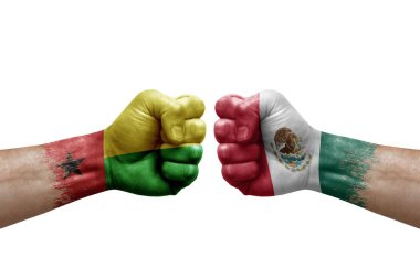 Two hands punch to each others on white background. Country flags painted fists, conflict crisis concept between guinea-bissau and mexico