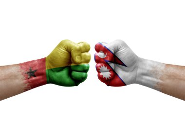 Two hands punch to each others on white background. Country flags painted fists, conflict crisis concept between guinea-bissau and nepal