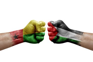 Two hands punch to each others on white background. Country flags painted fists, conflict crisis concept between guinea-bissau and palestine