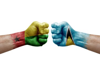 Two hands punch to each others on white background. Country flags painted fists, conflict crisis concept between guinea-bissau and saint lucia