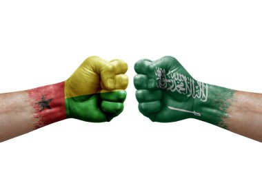 Two hands punch to each others on white background. Country flags painted fists, conflict crisis concept between guinea-bissau and saudi arabia