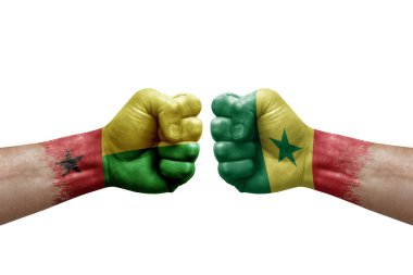 Two hands punch to each others on white background. Country flags painted fists, conflict crisis concept between guinea-bissau and senegal