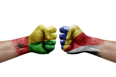 Two hands punch to each others on white background. Country flags painted fists, conflict crisis concept between guinea-bissau and seychelles