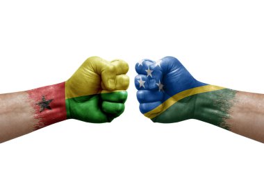 Two hands punch to each others on white background. Country flags painted fists, conflict crisis concept between guinea-bissau and solomon islands