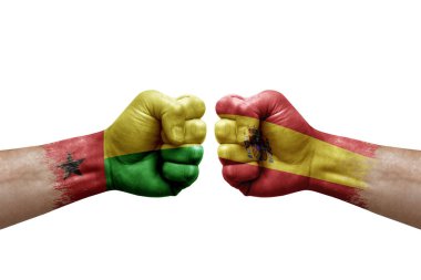 Two hands punch to each others on white background. Country flags painted fists, conflict crisis concept between guinea-bissau and spain
