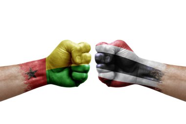 Two hands punch to each others on white background. Country flags painted fists, conflict crisis concept between guinea-bissau and thailand