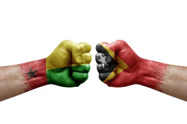 Two hands punch to each others on white background. Country flags painted fists, conflict crisis concept between guinea-bissau and timor leste