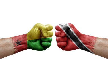 Two hands punch to each others on white background. Country flags painted fists, conflict crisis concept between guinea-bissau and tobago