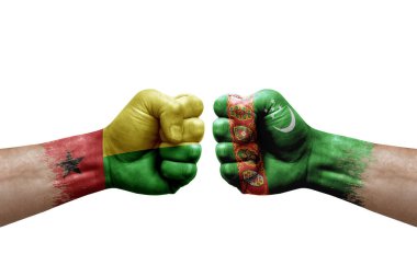 Two hands punch to each others on white background. Country flags painted fists, conflict crisis concept between guinea-bissau and turkmenistan