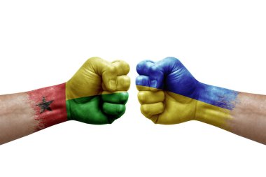 Two hands punch to each others on white background. Country flags painted fists, conflict crisis concept between guinea-bissau and ukraine