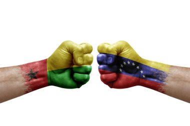 Two hands punch to each others on white background. Country flags painted fists, conflict crisis concept between guinea-bissau and venezuela