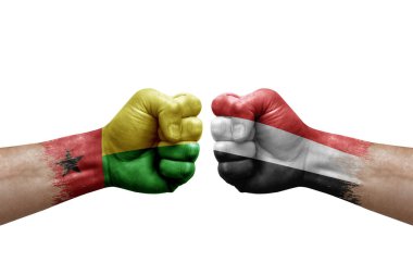 Two hands punch to each others on white background. Country flags painted fists, conflict crisis concept between guinea-bissau and yemen