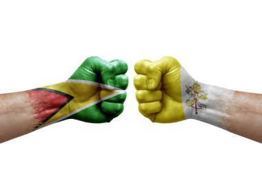 Two hands punch to each others on white background. Country flags painted fists, conflict crisis concept between guyana and holy see