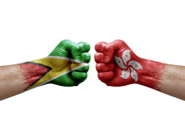 Two hands punch to each others on white background. Country flags painted fists, conflict crisis concept between guyana and hong kong