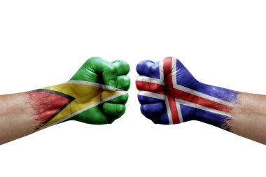 Two hands punch to each others on white background. Country flags painted fists, conflict crisis concept between guyana and iceland