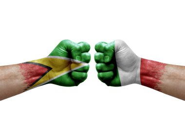 Two hands punch to each others on white background. Country flags painted fists, conflict crisis concept between guyana and italy