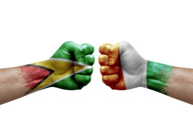 Two hands punch to each others on white background. Country flags painted fists, conflict crisis concept between guyana and ivory coast
