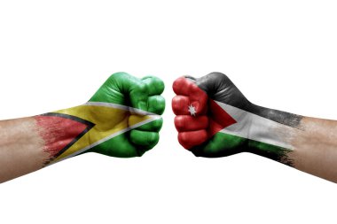 Two hands punch to each others on white background. Country flags painted fists, conflict crisis concept between guyana and jordan