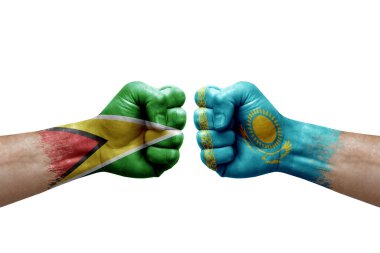 Two hands punch to each others on white background. Country flags painted fists, conflict crisis concept between guyana and kazakhstan