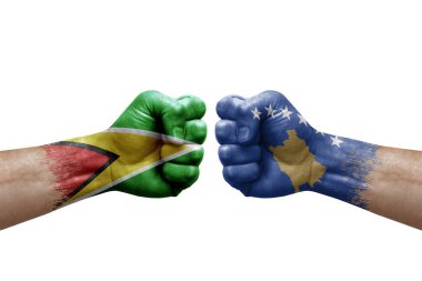 Two hands punch to each others on white background. Country flags painted fists, conflict crisis concept between guyana and kosovo