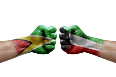 Two hands punch to each others on white background. Country flags painted fists, conflict crisis concept between guyana and kuwait